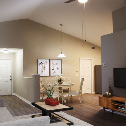 Furnished living room with view of dining room table and chairs.